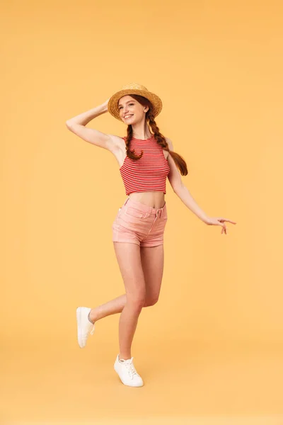 Joven alegre hermosa pelirroja posando aislada sobre fondo amarillo . — Foto de Stock