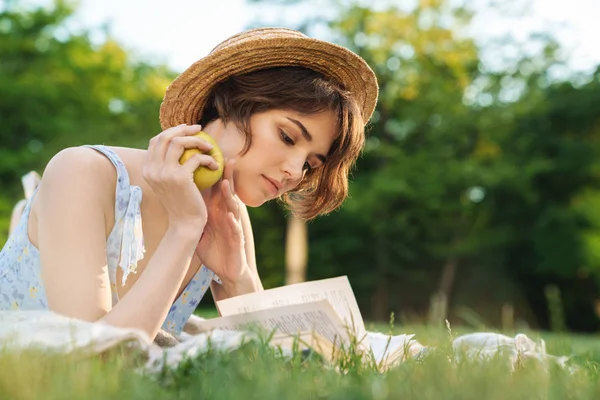 Bella giovane bella donna si trova sull'erba nel parco all'aperto libro di lettura . — Foto Stock