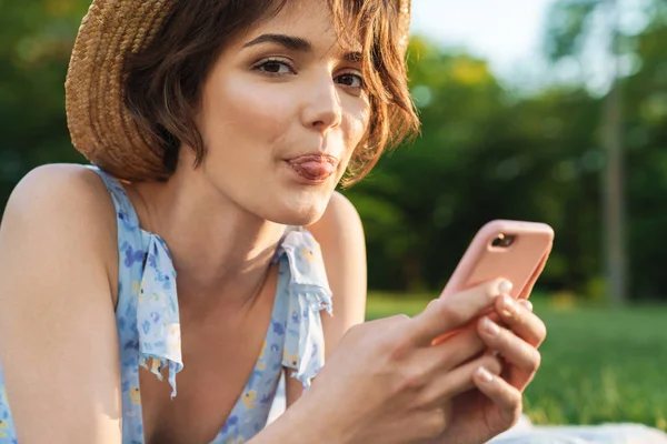 Güzel mutlu genç güzel kadın yeşil parkta açık havada cep telefonu kullanarak. — Stok fotoğraf