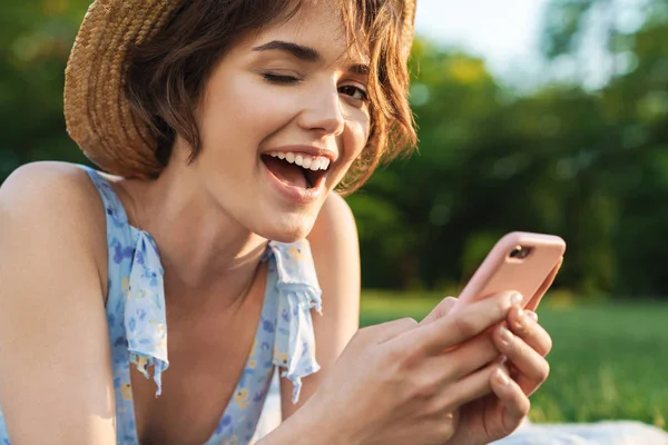 Szép boldog fiatal csinos nő a zöld parkban a szabadban mobiltelefon-használat. — Stock Fotó