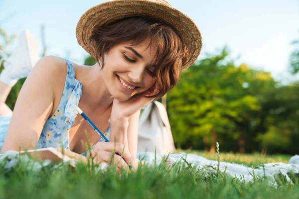 Bella scioccato giovane bella donna nel parco verde all'aperto scrivere note nel taccuino . — Foto Stock