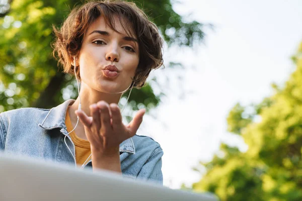 Imagen de encantadora mujer caucásica soplando beso de aire mientras usa s —  Fotos de Stock