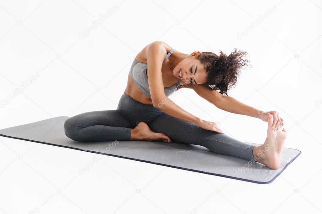 Amazing stronger sports fitness african woman make exercises isolated over white wall background.