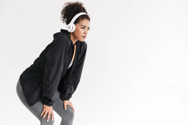 Beautful fiatal csodálatos sport fitness afrikai nő hallgat zenét fejhallgató izolált fehér háttér. — Stock Fotó