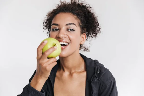 Beautful młody niesamowite sportowe fitness African kobieta jeść jabłko na białym tle. — Zdjęcie stockowe