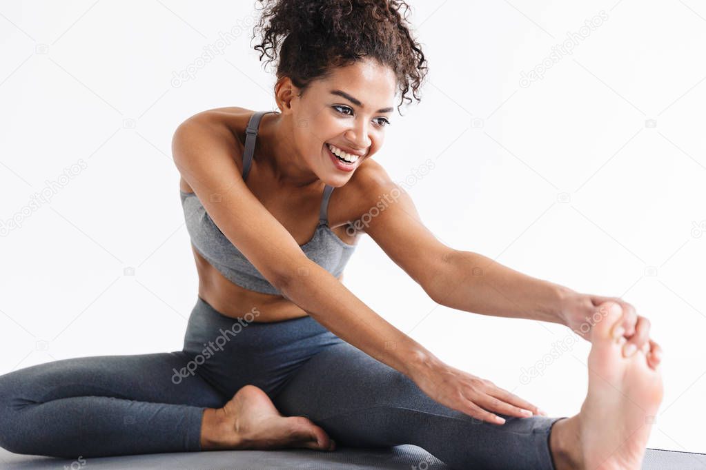 Amazing stronger sports fitness african woman make exercises isolated over white wall background.