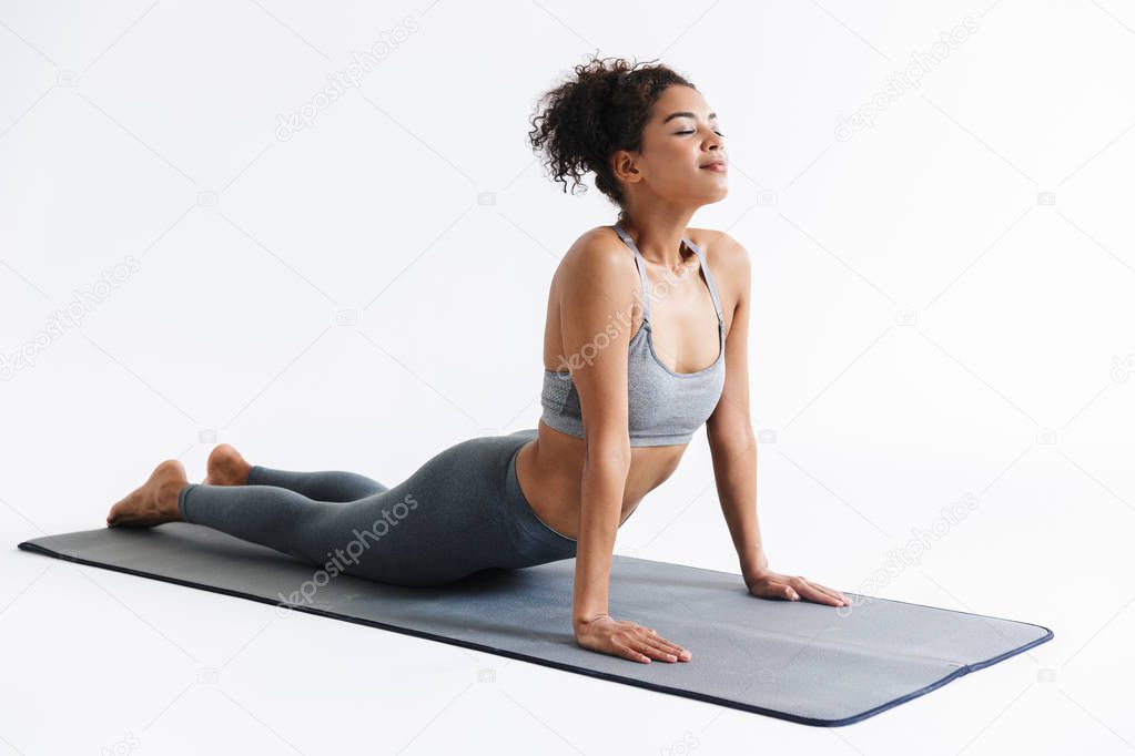 Amazing stronger sports fitness african woman make exercises isolated over white wall background.