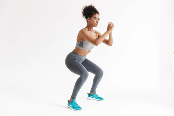 Elképesztő erősebb sport fitness afrikai nő, hogy gyakorlatokat elszigetelt fehér fal háttér. — Stock Fotó