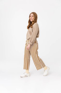 Neşeli sevimli genç genç kız beyaz duvar arka plan üzerinde izole kamera görünümlü yürüyüş.