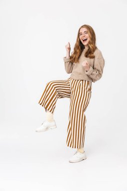 Heyecanlı sevimli genç genç kız beyaz duvar arka plan üzerinde izole poz kazanan jest yapmak.