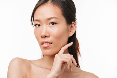 Beyaz duvar arka plan üzerinde izole poz sağlıklı cilt ile güzel pozitif asya genç güzel kadın.