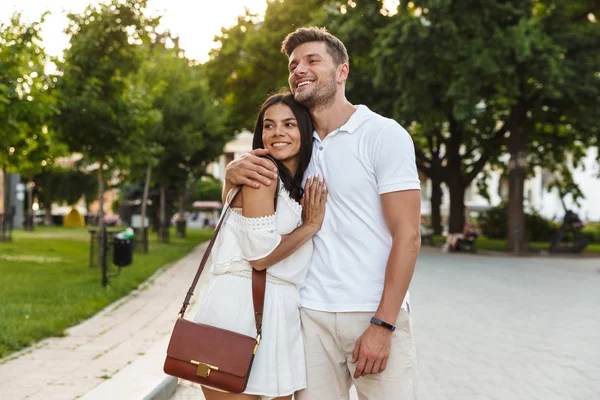 Retrato de alegre jovem casal sorrindo e abraçando juntos whi — Fotografia de Stock