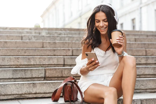 Retrato de una mujer joven y bonita con auriculares y smartphone w — Foto de Stock