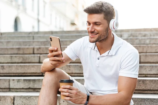 Portret van mannelijke jonge man met koptelefoon en smartphone — Stockfoto