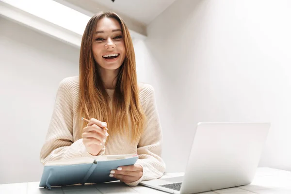 Atraktivní mladá dívka, která sedí doma v kuchyni — Stock fotografie