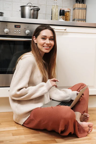 Mutfakta bir katta oturan neşeli genç kız — Stok fotoğraf