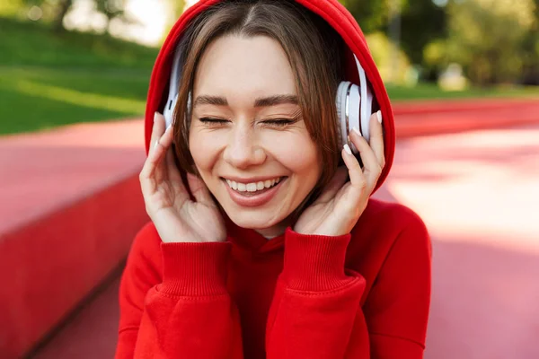 Jeune femme souriante portant un sweat à capuche — Photo