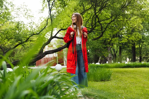 Cheerful attractive young girl wearing raincoat — Stock Photo, Image