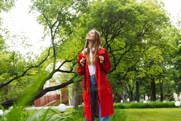 Cheerful attractive young girl wearing raincoat — Stock Photo, Image