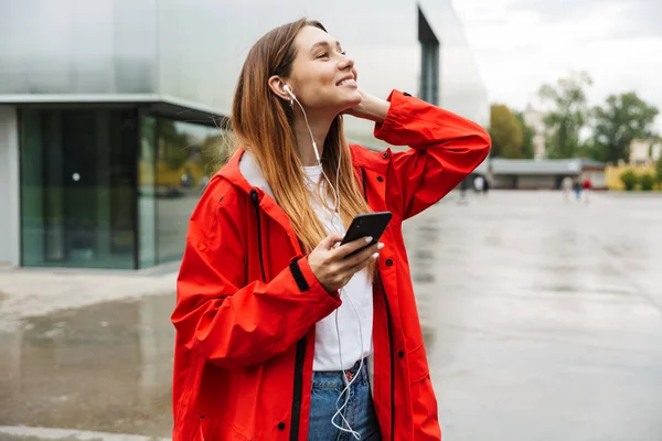 Jovencita atractiva alegre vistiendo impermeable —  Fotos de Stock