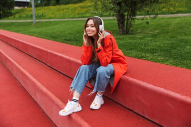 Yağmurluk giyen chherful çekici genç kız