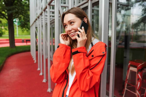 Veselá atraktivní mladá dívka v pláštěnce — Stock fotografie