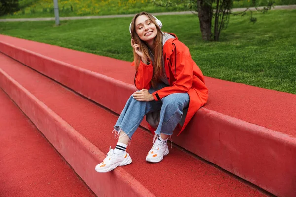 Chherful joven atractiva con impermeable —  Fotos de Stock