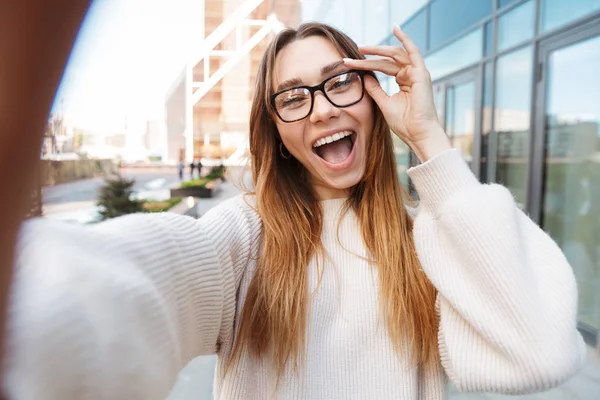 Empresária excitada posando andando ao ar livre perto do centro de negócios usando óculos tirar selfie por câmera . — Fotografia de Stock