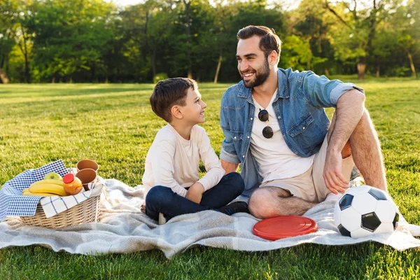 Feliz joven padre haciendo un picnic con su pequeño hijo — Foto de Stock