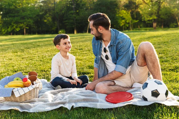 Gelukkige jonge vader met een picknick met zijn kleine zoon — Stockfoto