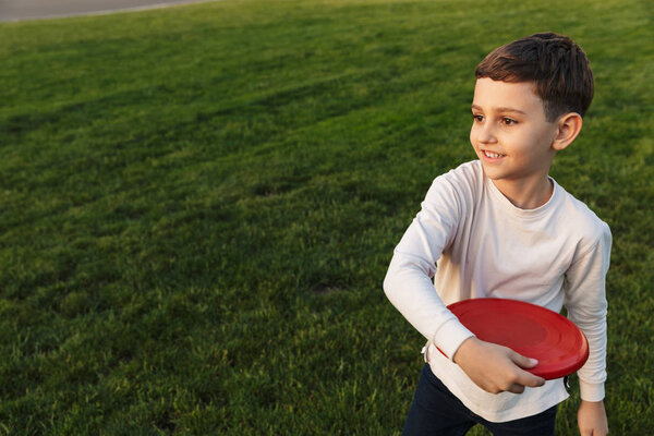 Boy outoors in park beautiful green grass play game with father.