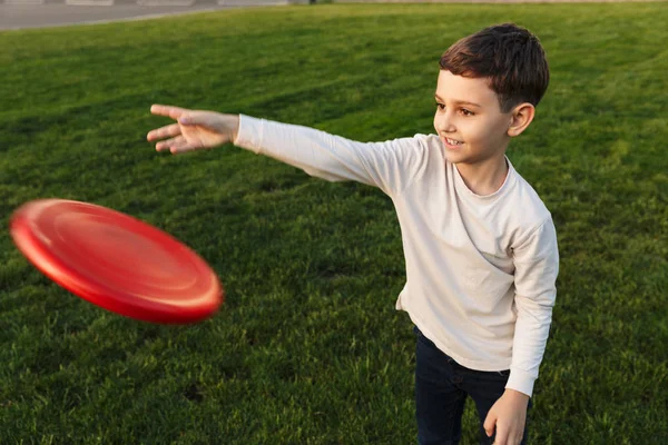 Fechar de um miúdo feliz a jogar frisbee — Fotografia de Stock