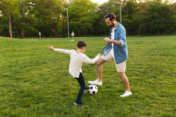 Dos hermanos alegres jugando al fútbol en el césped — Foto de Stock