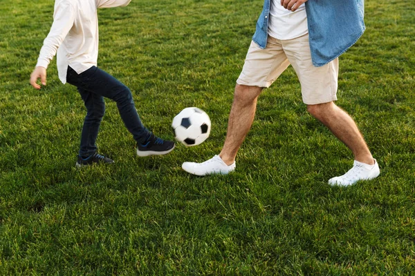 İki neşeli kardeş çimenlikte futbol oynuyor — Stok fotoğraf