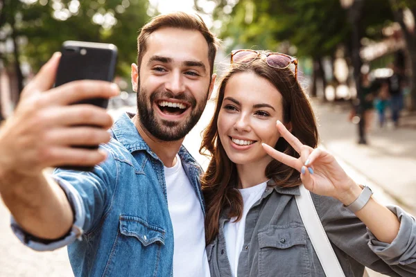 Mooie jonge paar in liefde staande buitenshuis — Stockfoto