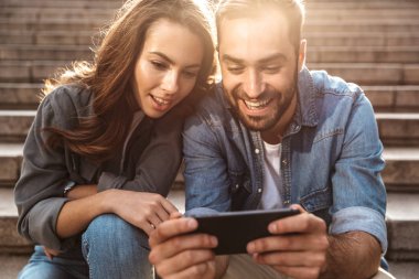 Açık havada merdivenlerde oturan çekici genç çift