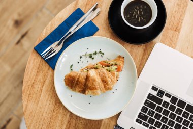 Kruvasan ve kahve fincanı ile bir iş öğle yemeği üst görünümü