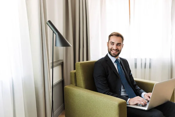 Attractive young businessman wearing suit sitting in a chair — Stock Photo, Image