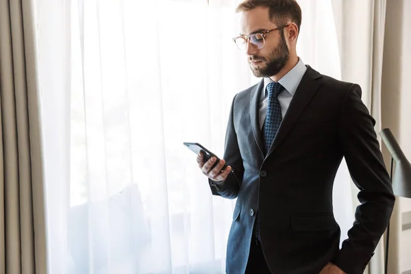 Atractivo joven empresario con traje de pie — Foto de Stock