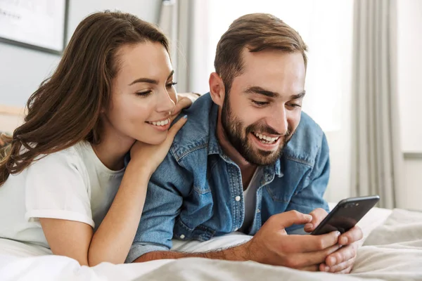 Beautiful young couple in love at home, laying in bed — Stock Photo, Image