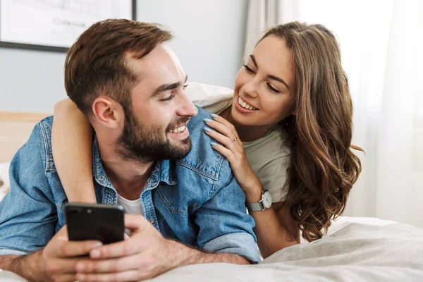 Beautiful young couple in love at home, laying in bed — Stock Photo, Image