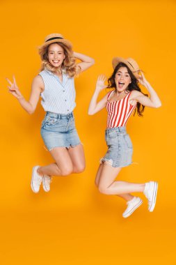İki neşeli sarışın ve esmer kadın portresi 20s hasır şapkalar barış şarkı ve atlama gesturing