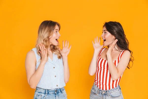 Portrait of two lovely blonde and brunette women 20s in summer wear expressing delight while raising arms — Stock Photo, Image