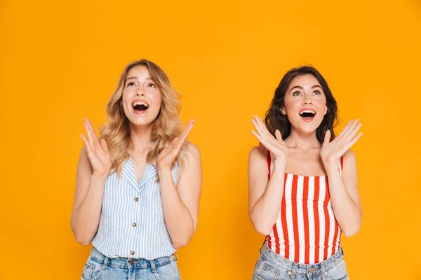 Portret van twee mooie blonde en brunette vrouwen 20s in de zomer slijtage uitdrukken genot tijdens het aantrekken van armen — Stockfoto