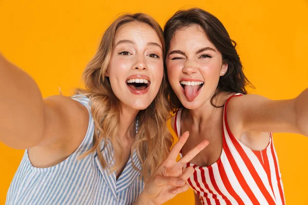 Portret close-up van twee amusende blonde en brunette vrouwen 20s in de zomer slijtage glimlachen tijdens het kijken naar de camera — Stockfoto