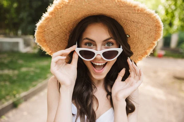 Foto primo piano di deliziata donna caucasica indossando cappello di paglia e — Foto Stock