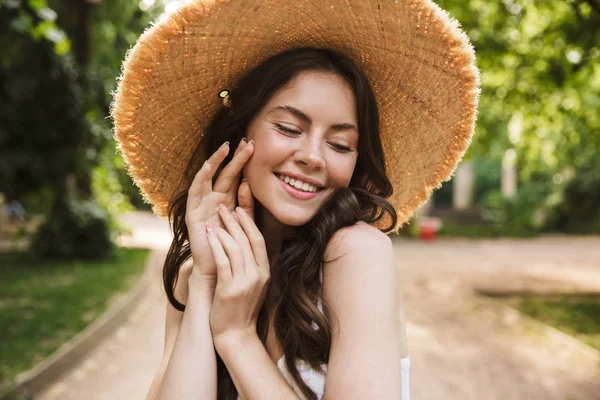 Emocionado feliz joven bonita mujer salidas en verde parque caminando en sombrero . — Foto de Stock