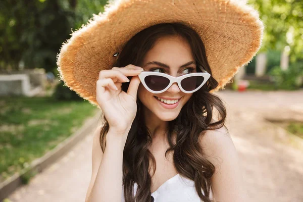Boldog ifjú csinos nő outoors zöld parkban Walking in kalap. — Stock Fotó