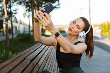 Esmer sporcunun selfie fotoğrafı çekerken kulaklıkla görüntüsü 