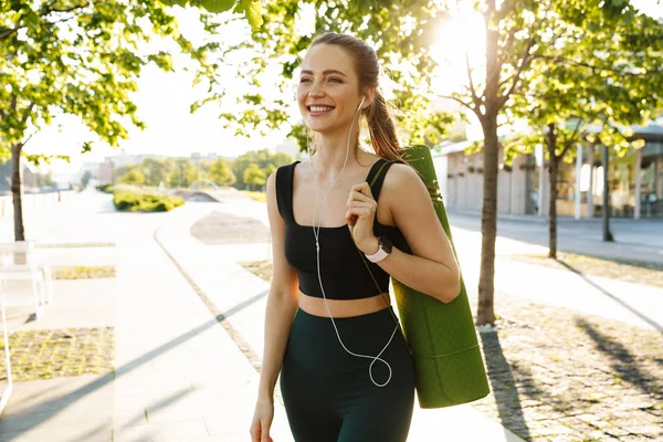 Beeld van slim Sportvrouw luisteren naar muziek met oortelefoons en — Stockfoto